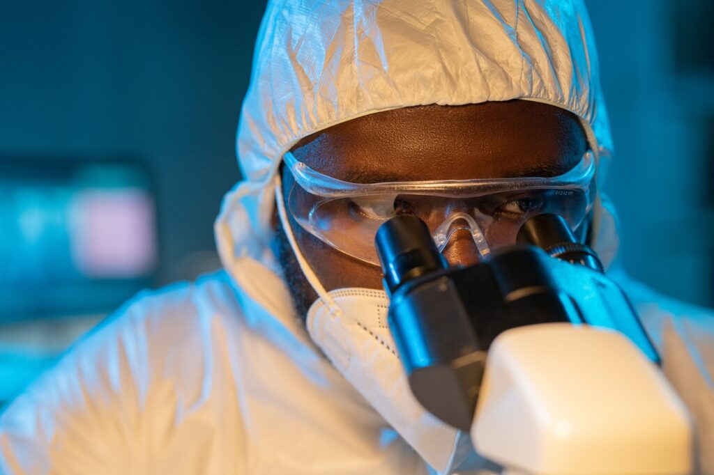 Close-up of young African American scientist looking in microscope Close-up of young African American scientist looking in microscope